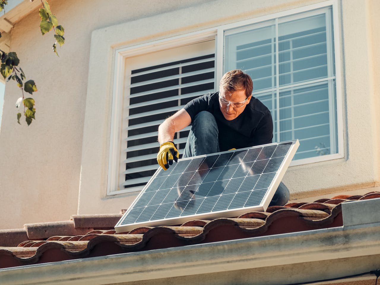 pexels-photo-9875408 Man with Gloves Holding Solar Panels on the Roof